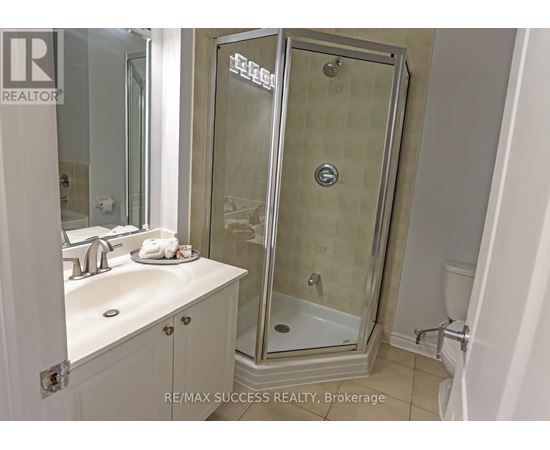 A bathroom with a glass shower door and a white sink.