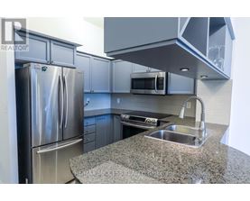 A kitchen with a granite countertop and stainless steel appliances.