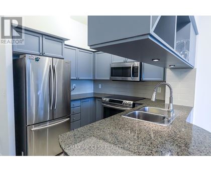 A kitchen with a granite countertop and stainless steel appliances.