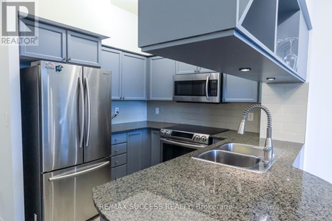 A kitchen with a granite countertop and stainless steel appliances.