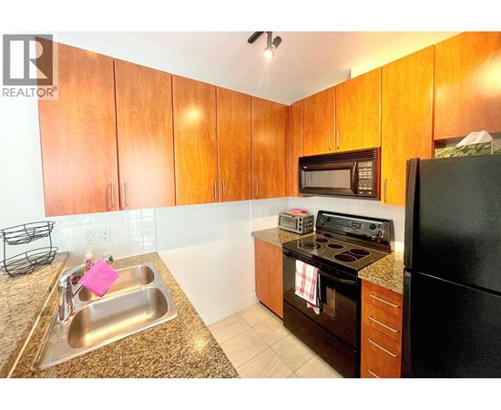 A kitchen with wooden cabinets and black appliances.
