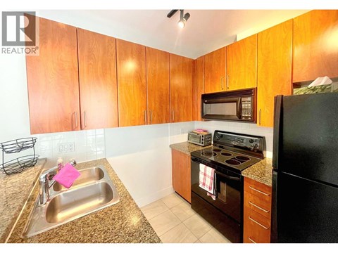 A kitchen with wooden cabinets and black appliances.