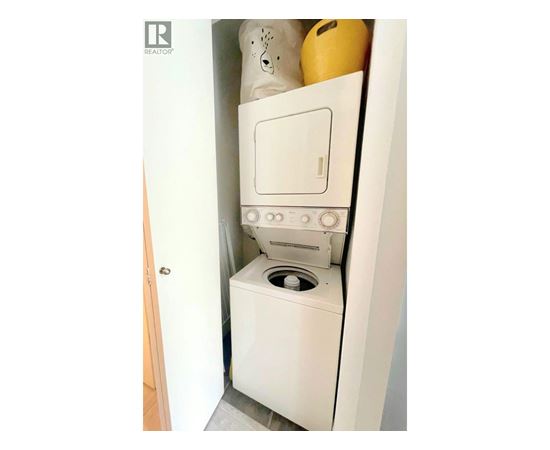 A white washing machine is installed in a small space.