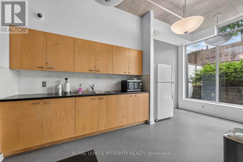 A kitchen with wooden cabinets and a black countertop.