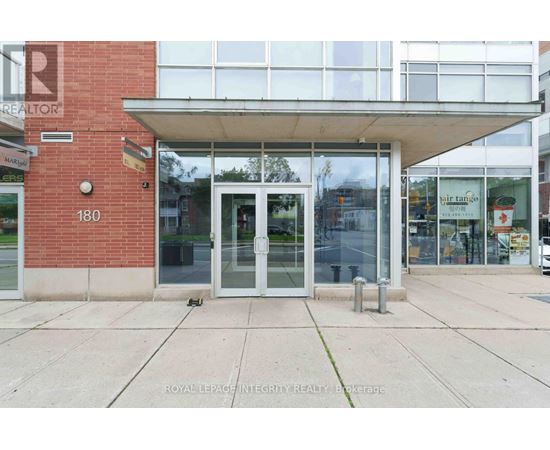 The image shows the front of a building with a glass door and windows.