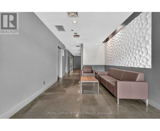 A spacious room with a long hallway, a couch, and a table.