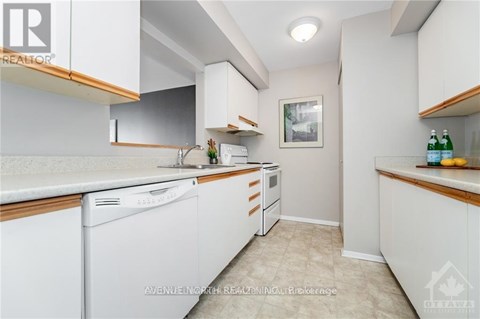 A white kitchen with a dishwasher and a refrigerator.