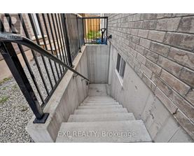 A staircase with a black railing leads up to a door.