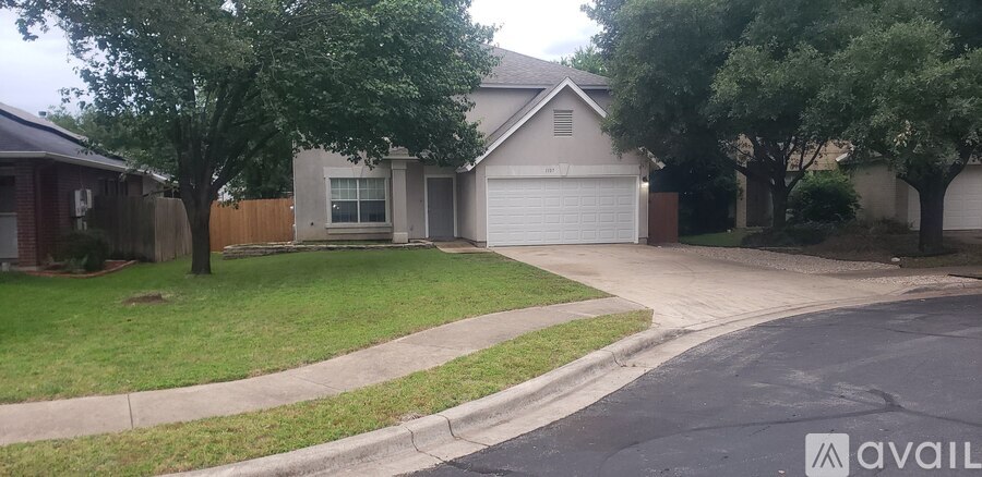 A house with a garage and a driveway in front of it.