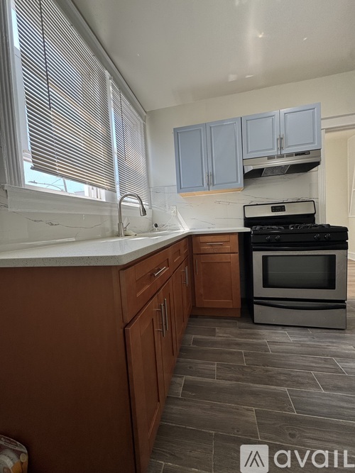 A kitchen with wooden cabinets and a black stove top oven.