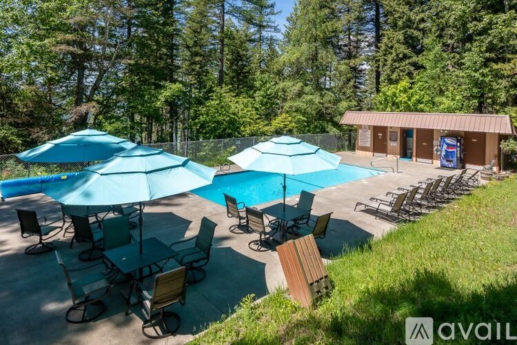 A pool area with blue umbrellas and chairs.