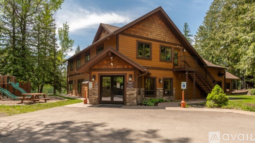 A large wooden lodge with a playground in front.