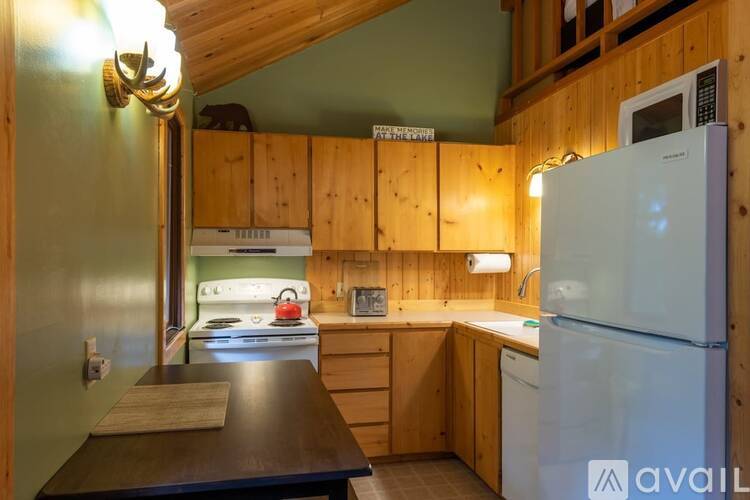 A kitchen with a white fridge and wooden cabinets.