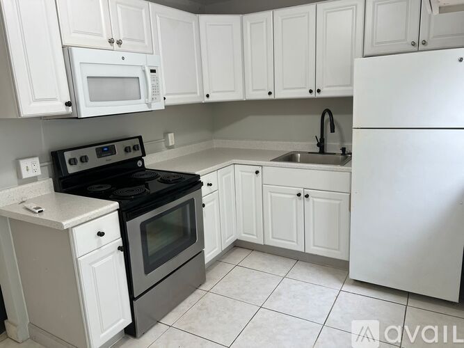 A kitchen with white appliances and cabinets.