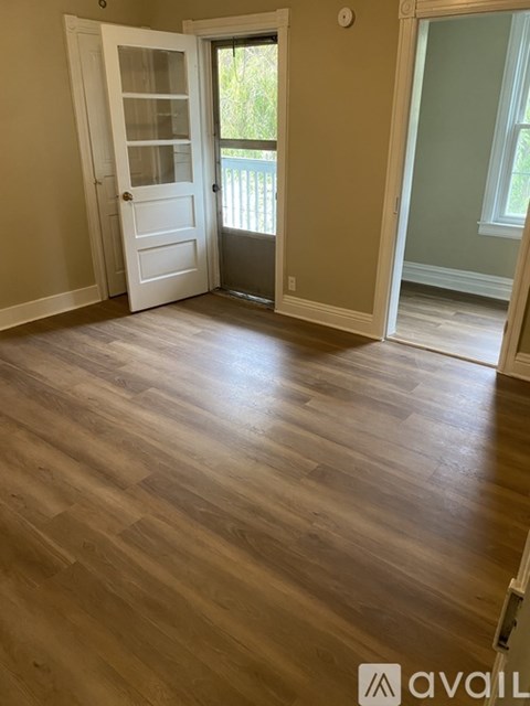 A room with wooden flooring and a white door.