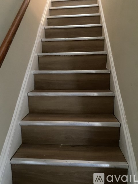 A brown wooden staircase with white edges.