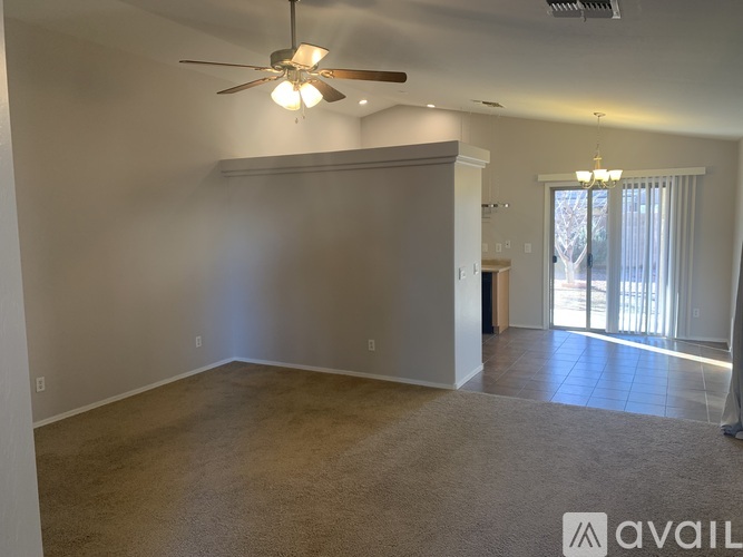 A spacious room with a ceiling fan and a carpeted floor.