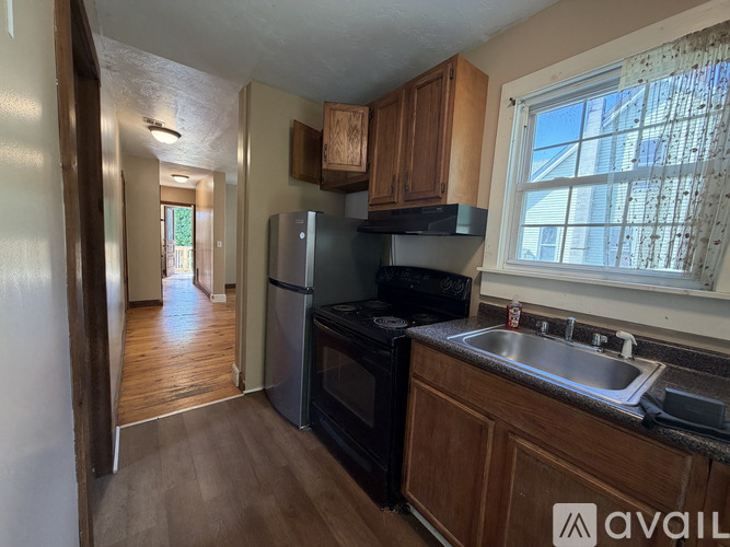 A kitchen with wooden cabinets and a stainless steel refrigerator.