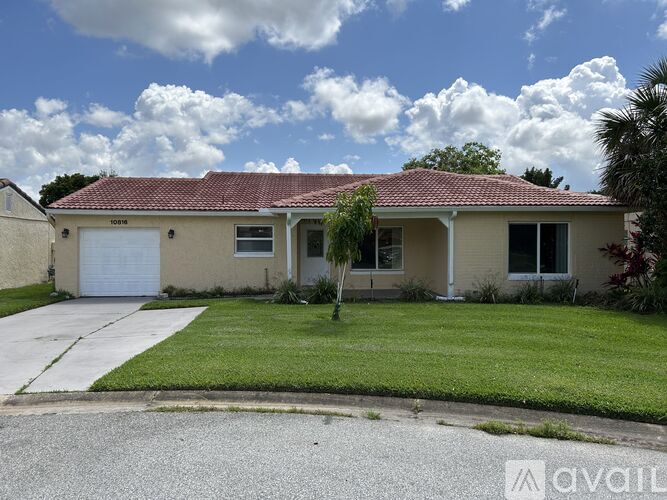 A house with a red roof and a white garage door is for sale.