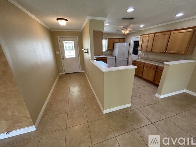 A kitchen with tan walls and a white refrigerator.