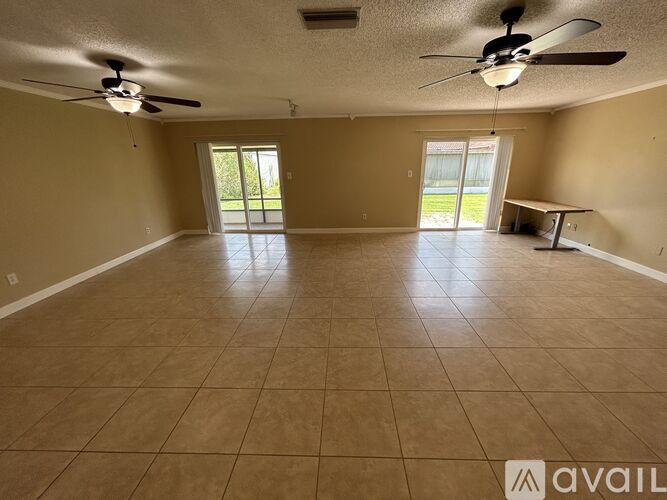 A spacious room with a ceiling fan and tile flooring.