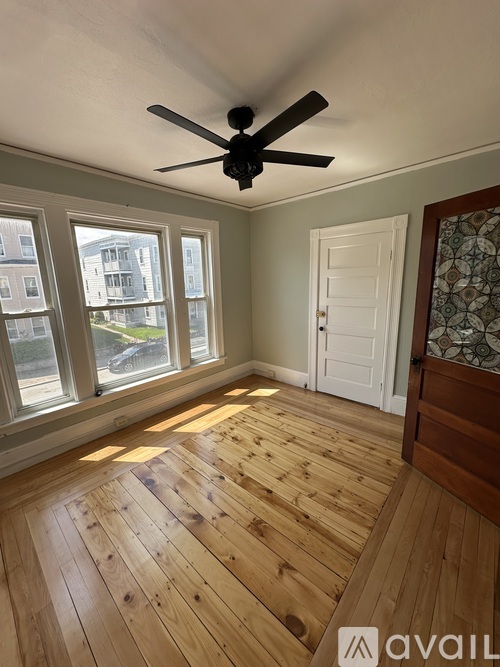 A room with wooden flooring and a ceiling fan.