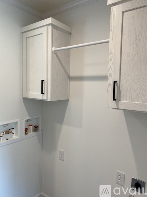 A white kitchen cabinet with a shelf underneath it.