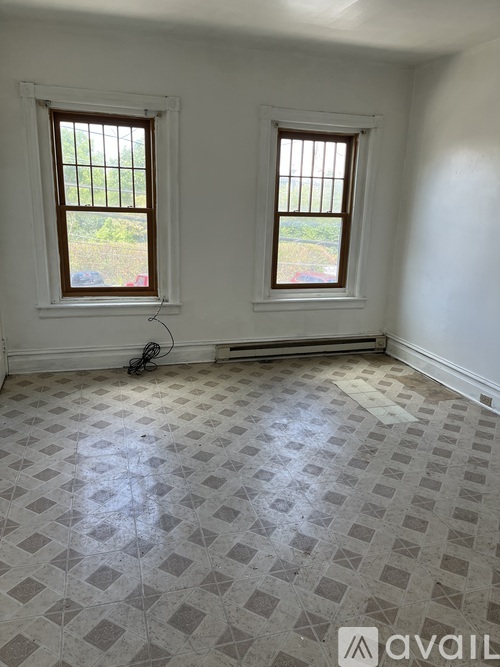 A room with two windows and a tiled floor.