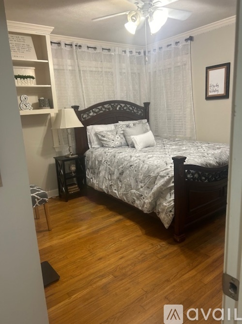 A bedroom with a bed, nightstand, and lamp.