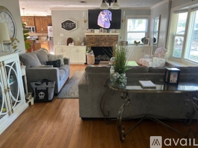 A living room with a grey couch and a fireplace.