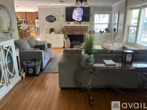 A living room with a grey couch and a fireplace.