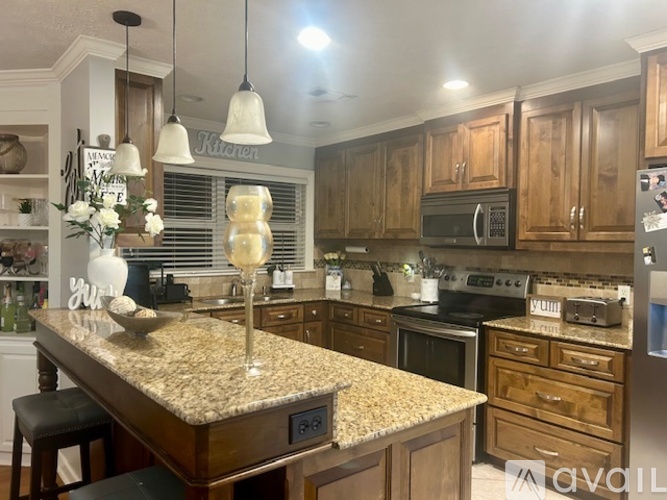 A kitchen with granite countertops and wooden cabinets.
