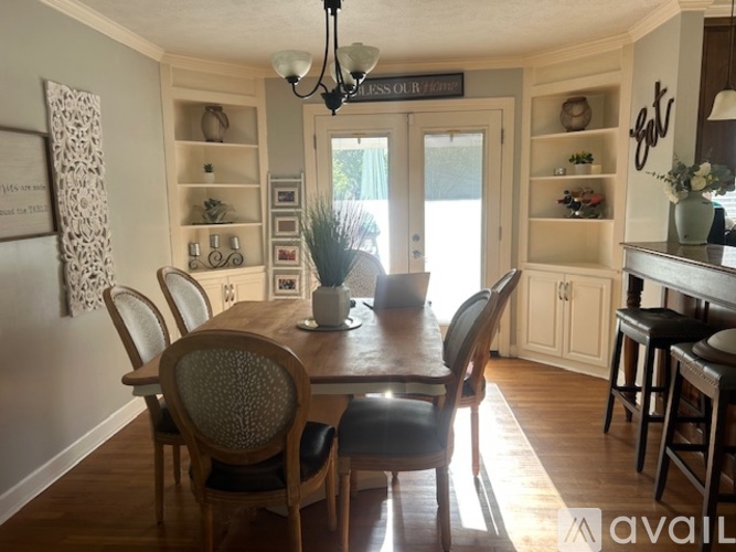 A dining room with a wooden table and chairs.