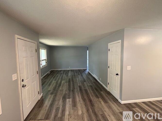 A room with wood flooring and two white doors.