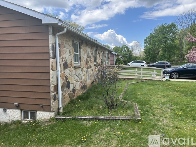 A house with a brown siding and a stone wall.