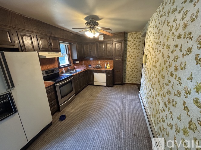 A kitchen with a white refrigerator and wooden cabinets.
