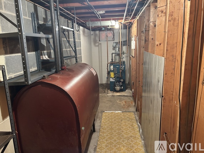 A large brown cylindrical object is in the center of a narrow industrial space.