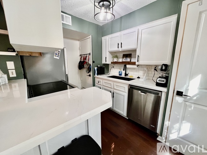 A kitchen with white cabinets and a white counter top.