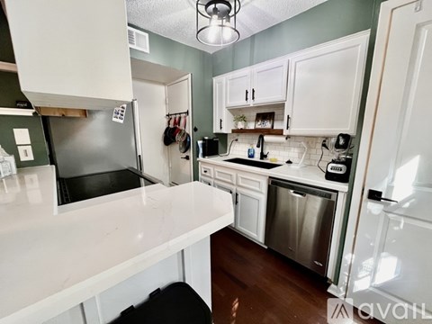 A kitchen with white cabinets and a white counter top.