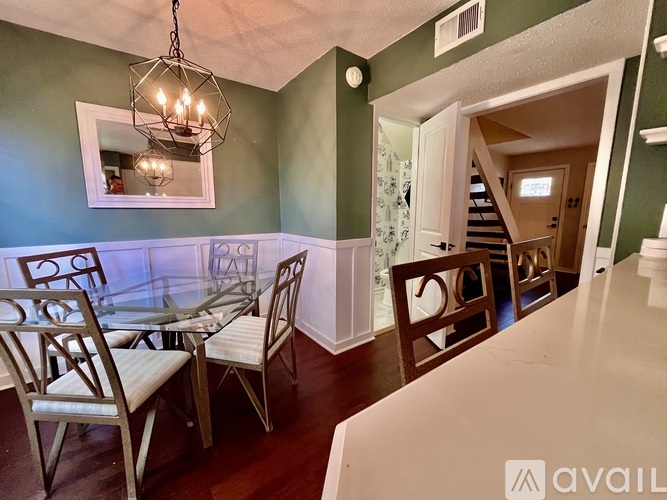 A dining room with a glass table and chairs.