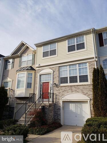 A two-story house with a red door and a garage.