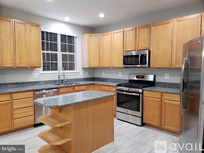 A kitchen with wooden cabinets and a granite countertop.