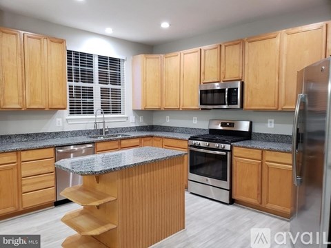A kitchen with wooden cabinets and a granite countertop.
