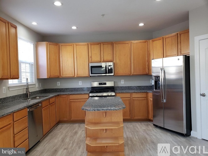 A kitchen with wooden cabinets and a granite countertop.