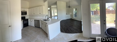 A kitchen with white cabinets and a black counter top.