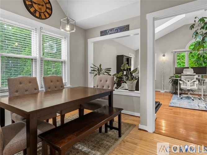 A dining room with a wooden table and chairs.