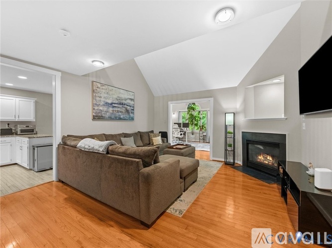 A living room with a brown couch and a fireplace.