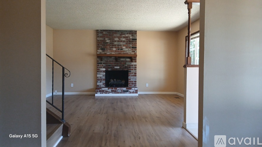 A living room with a fireplace and wooden floors.