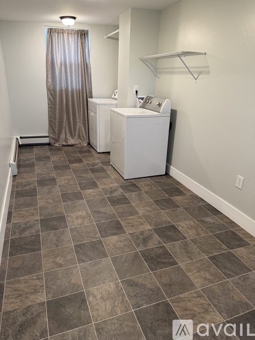 A bathroom with a tiled floor and a white sink.
