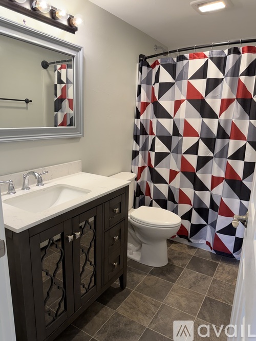 A bathroom with a black and white shower curtain.